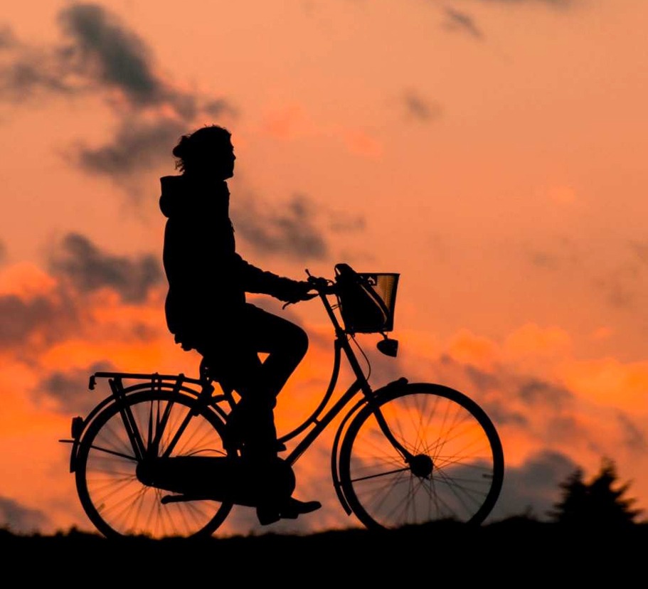 Silhuett av cyklist i solnedg&aring;ng.