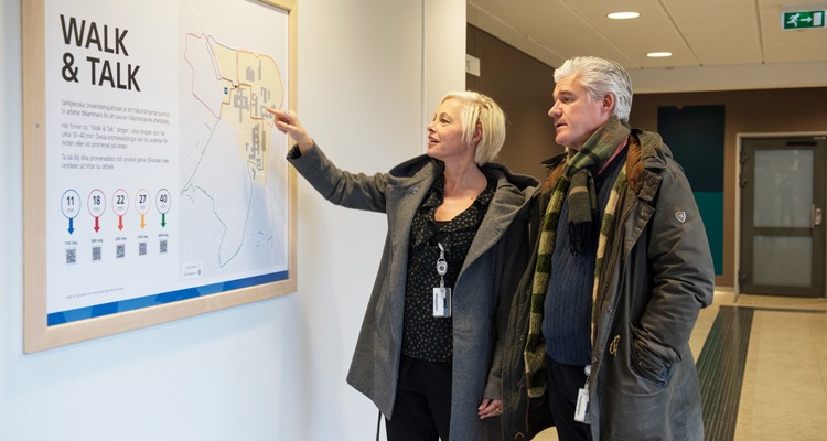 walk and talk tavla i netrén till Östra sjukhuset, Göteborg. Britt-Marie Zaman och Ingemar Blomqvist står intill tavlan och tittar på den.