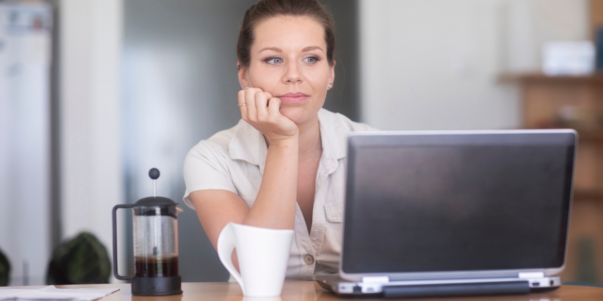 En kvinna sitter vid en laptop och ser avslappnad ut, tema hj&auml;rnv&auml;nlig arbetsplats.