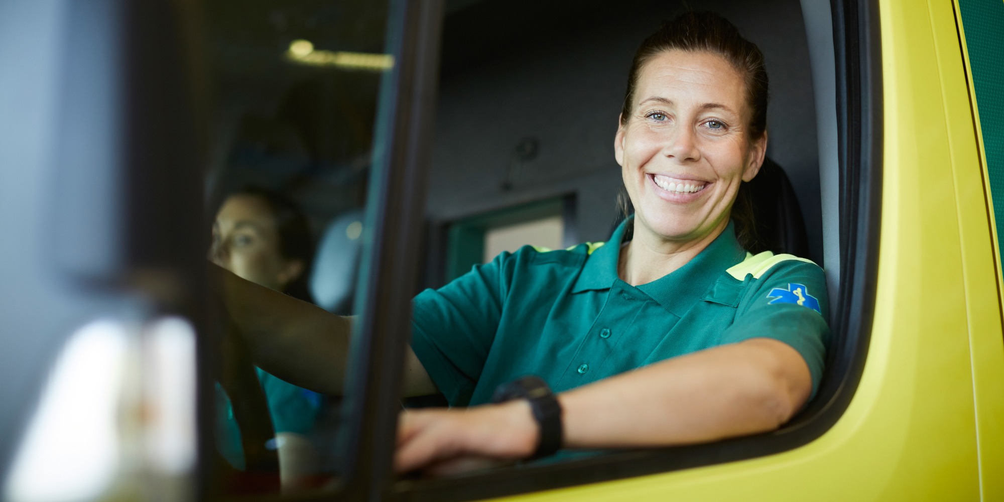 En kvinna sitter vid f&ouml;rarplatsen i en ambulans