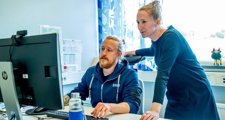 Sara Fischer, säkerhetschef på Bostadsbolaget, och skyddsombudet Simon Kappelmark tittar på en dator tillsammans.