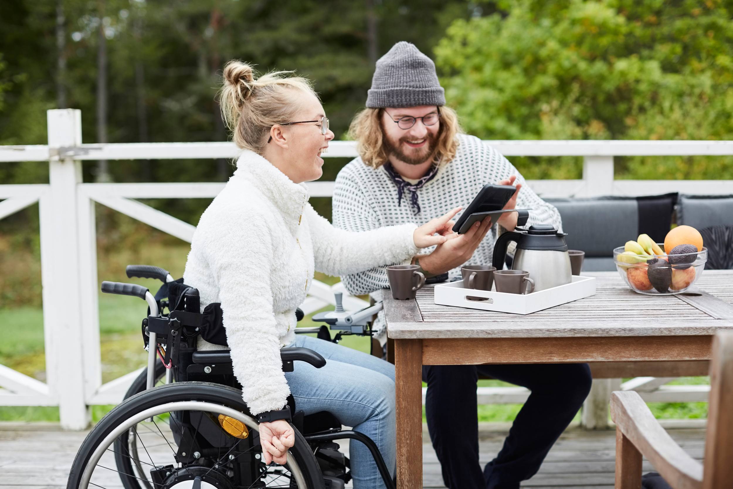 En man som jobbar som personlig assistent tittar p&aring; en l&auml;splatta tillsammans med en ung kvinna i rullstol. Han har 11 timmars dygnsvila mellan sina arbetspass.