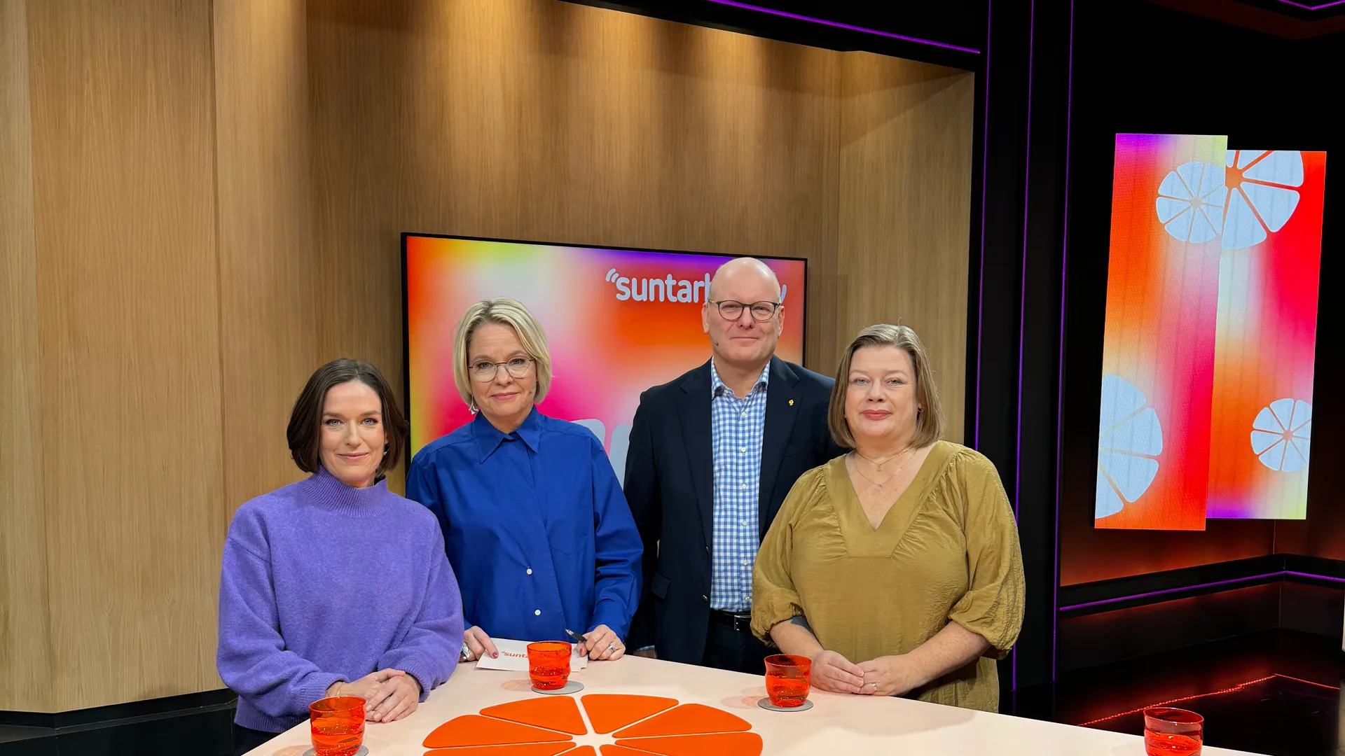 En grupp m&auml;nniskor som st&aring;r runt ett bord