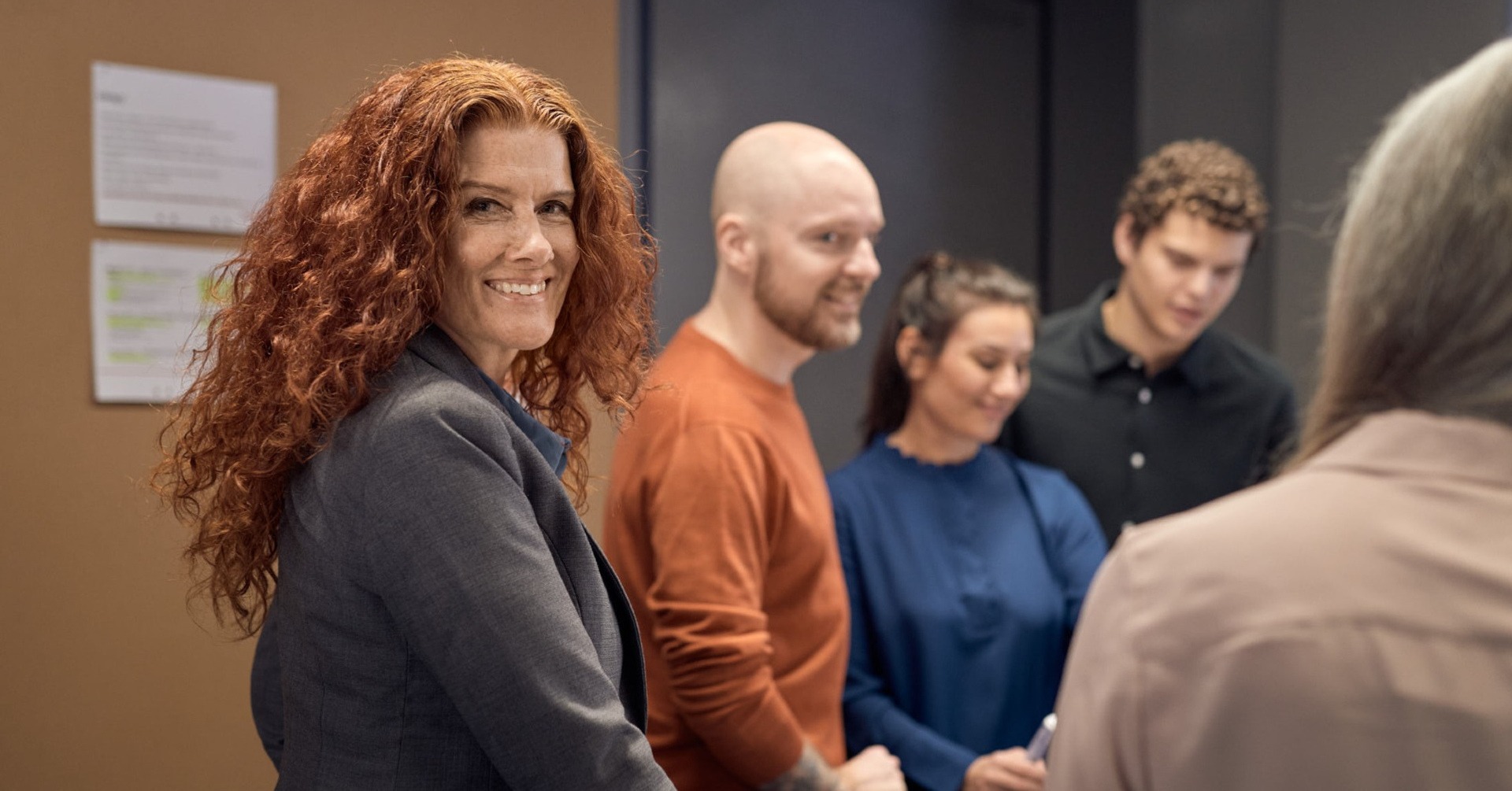 En grupp m&auml;nniskor st&aring;r i ett rum tillsammans.