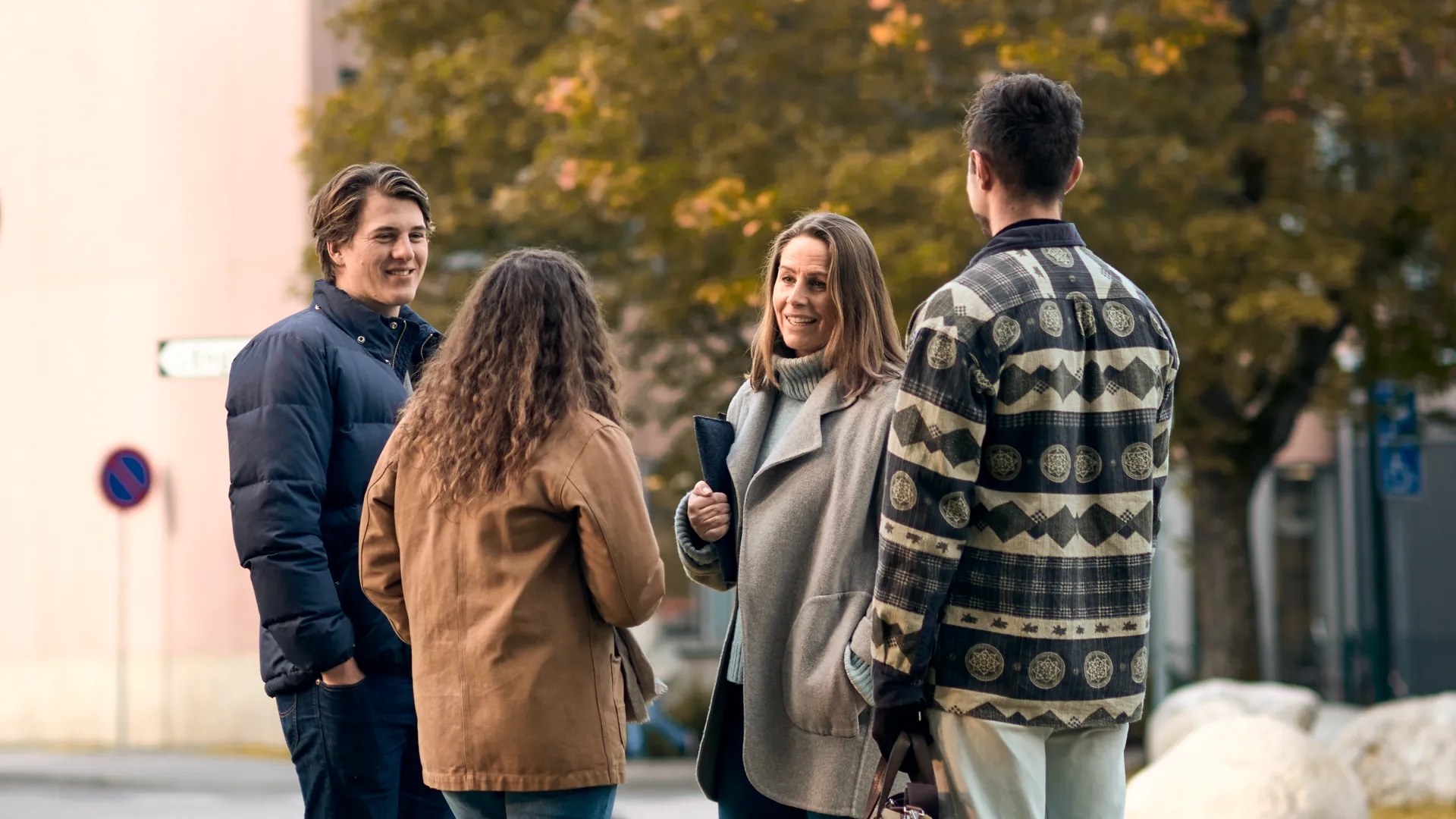 En grupp m&auml;nniskor st&aring;r utomhus och pratar.
