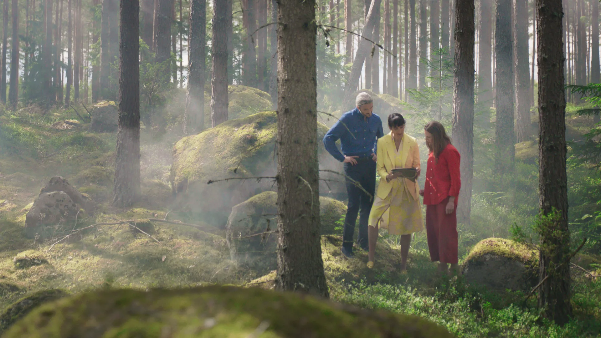 Chef, skyddsombud och medarbetare tittar p&aring; en karta i skogen.