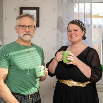 En manlig undersk&ouml;terska och hans kvinnliga chef st&aring;r i fikarummet och dricker kaffe.