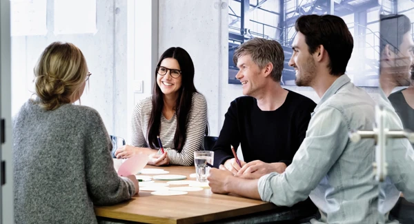 En grupp personer sitter i ett m&ouml;tesrum och pratar.