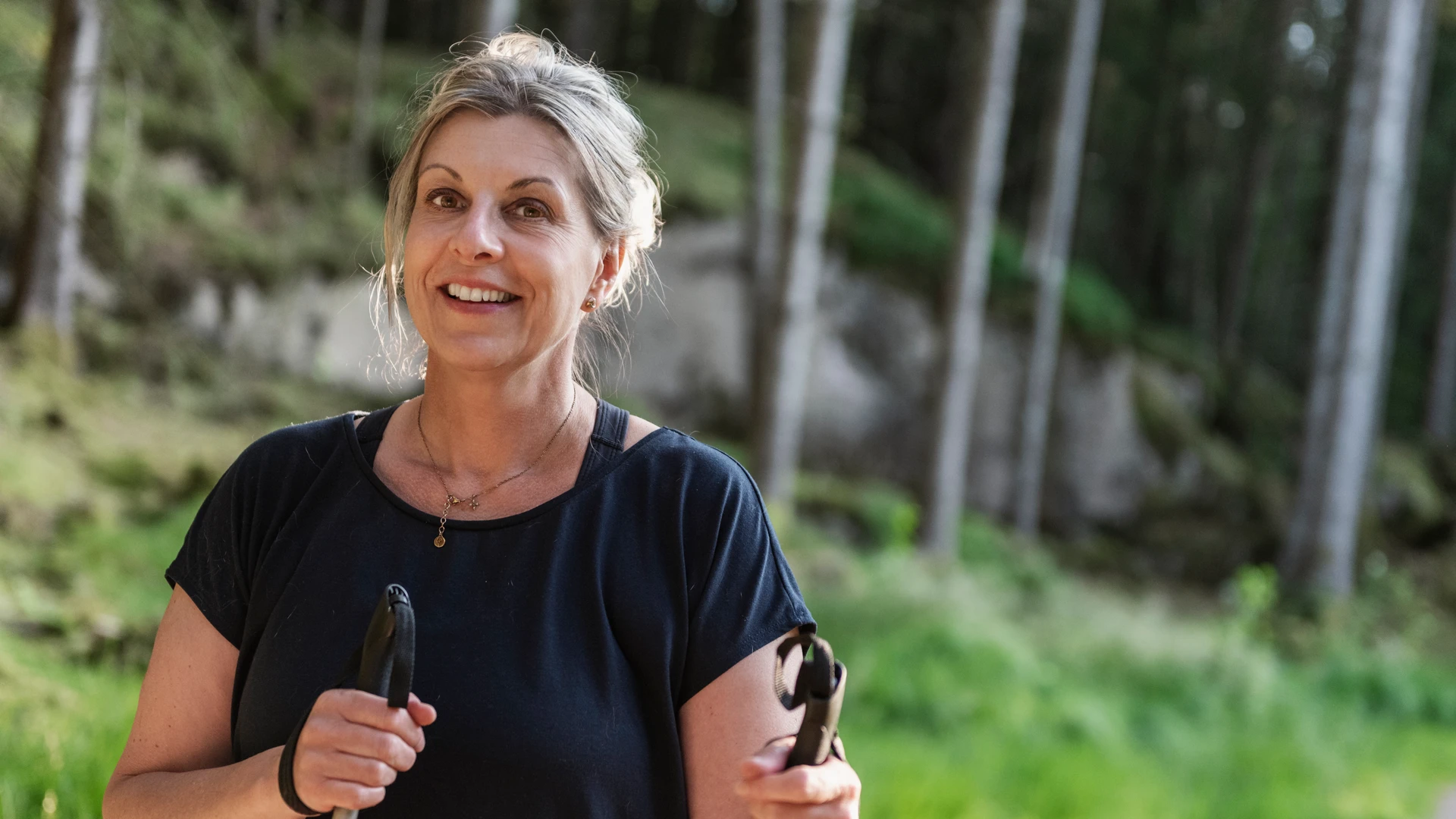 En kvinna som &auml;r ute och g&aring;r i naturen.