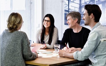 En grupp m&auml;nniskor som sitter runt ett tr&auml;bord.